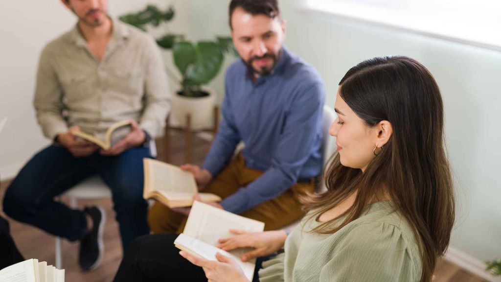 Tres persones llegint un llibre